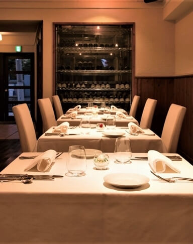 テーブルの上にカトラリーとワイングラスが並べられているデジーノの会場