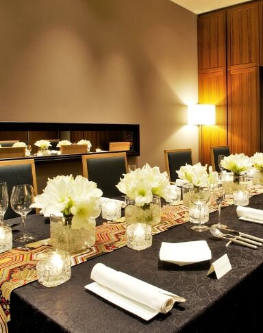 テーブルの上にカトラリーと白い花が並べられているラリアンスの個室