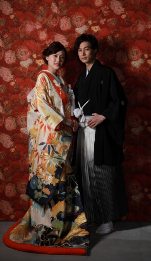 背中を向け、肩を寄せ合う着物姿の新郎新婦