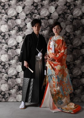 椅子に座る花嫁の傍らに立つ紋付袴の新郎